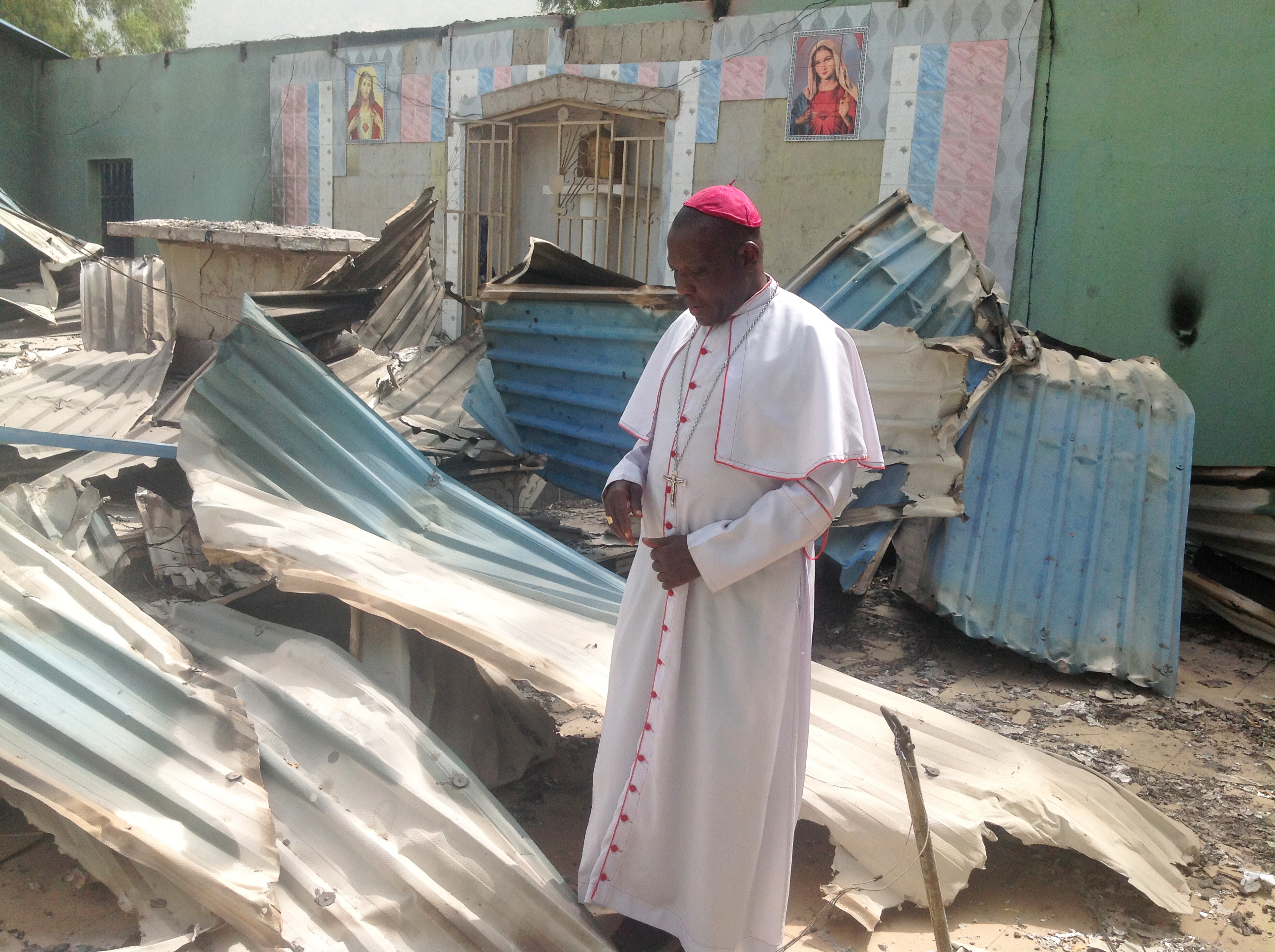 Bishop Doeme amid the ruins of one of the Churches in his ca