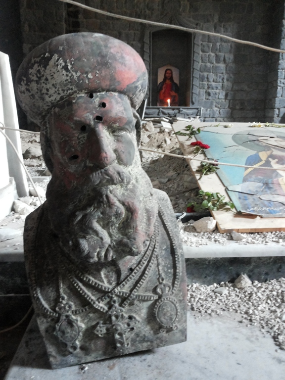 Statue of St. Efrem outside damaged Syriac Orthodox Church o